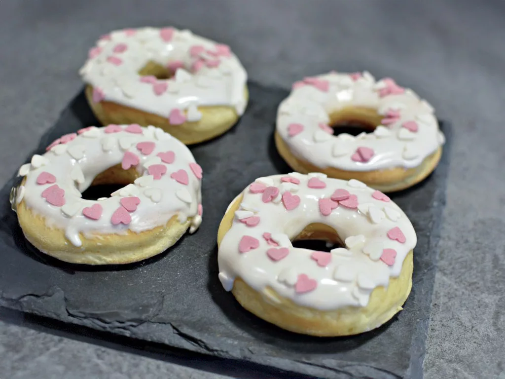 Donuts au four recouvert d'un glacage blanc et des petits coeurs blanc et roses