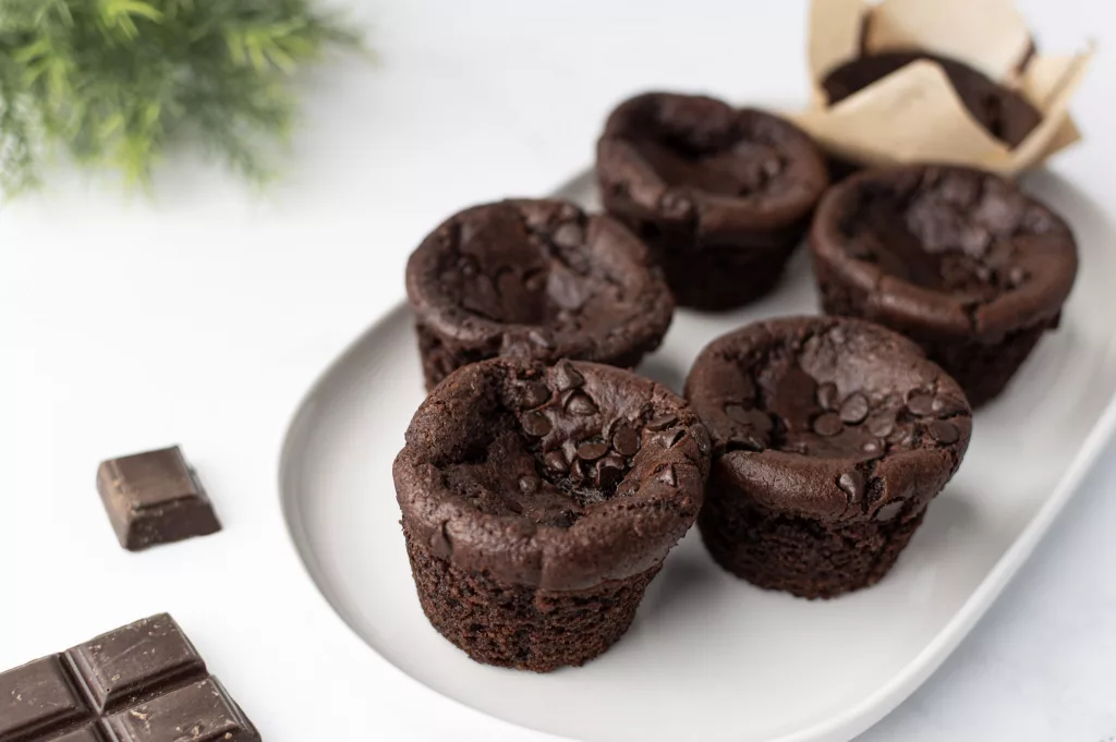 Muffins au chocolat vegan et pommes de terre sur un plat blanc et quelques carrés de chocolat autour