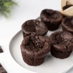Muffins vegan au chocolat et pommes de terre : recette facile Muffins au chocolat vegan et pommes de terre sur un plat blanc et quelques carrés de chocolat autour