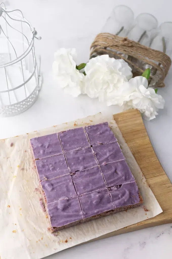 Brownie ube violet chocolat blanc coupé sur papier alimentaire sur une planche en bois