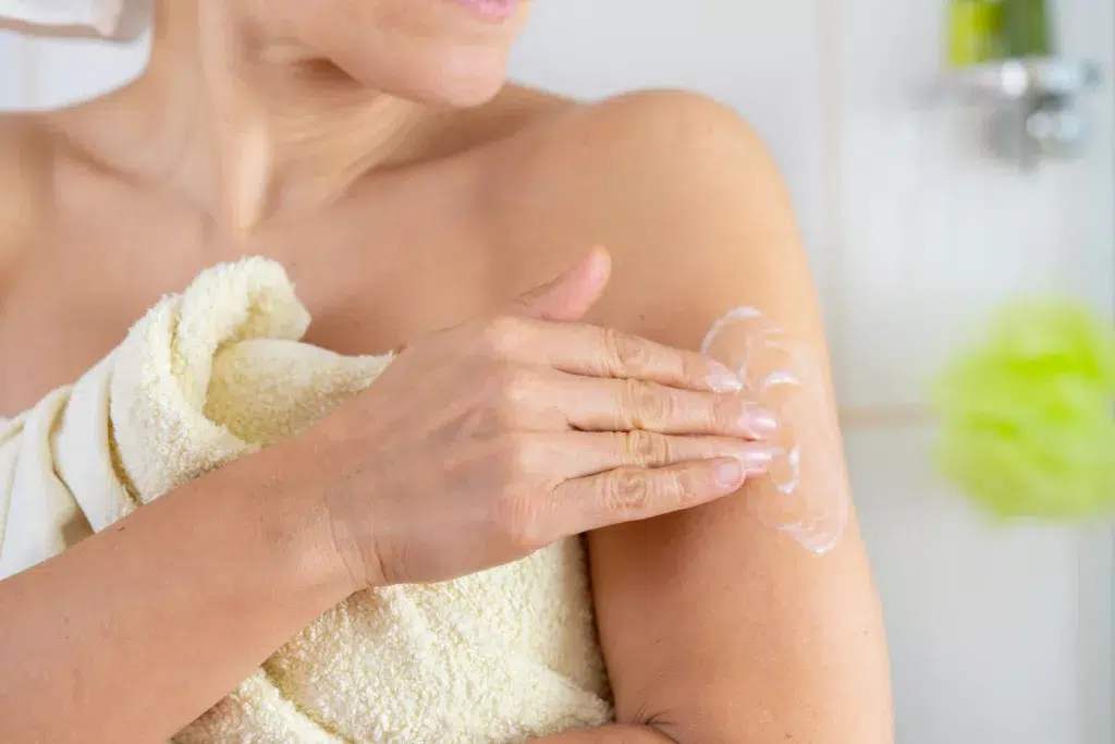 Femme appliquant un sérum au collagène et acide hyaluronique sur son décolleté"