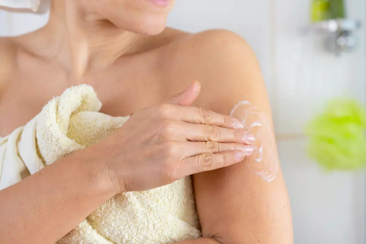Femme appliquant un sérum au collagène et acide hyaluronique sur son décolleté"
