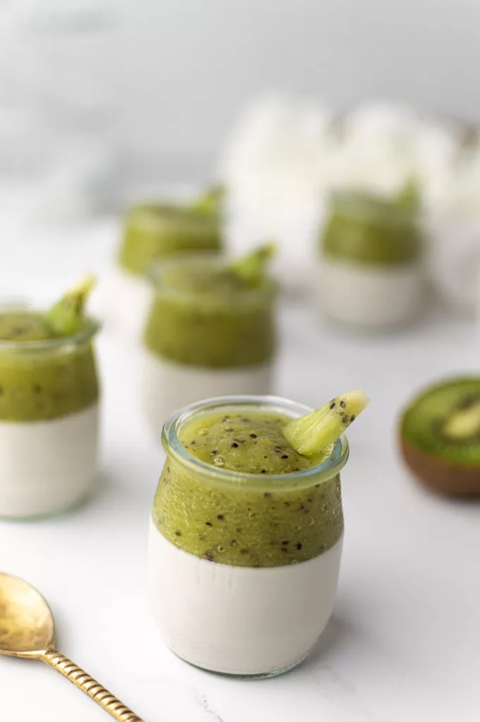 Verrines panna cotta lait de coco et purée de kiwi dans des pots en verre, vue rapprochée